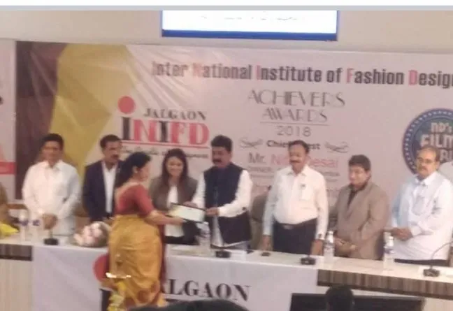 Archana Patil receiving the INIFD Achievers Award 2018 on stage in Jalgaon